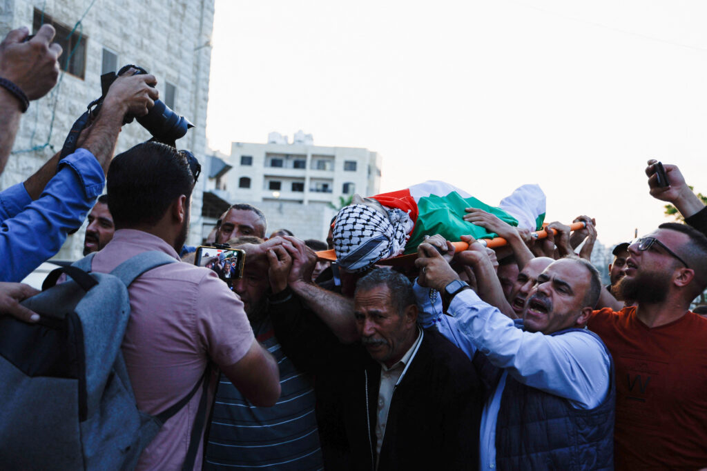 Mourners carry the body of Palestinian Moath Odeh who was killed in clashes with Israeli settlers and security forces